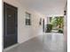 Outdoor hallway featuring neutral paint, dark door, and view of the surrounding trees at 640 N Nova Rd # 117, Ormond Beach, FL 32174