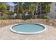 Relaxing community hot tub area with pavers, surrounded by a lush green space and condo buildings at 640 N Nova Rd # 117, Ormond Beach, FL 32174