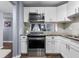Well-lit kitchen with stainless steel stove and microwave, complemented by stylish white cabinets at 640 N Nova Rd # 117, Ormond Beach, FL 32174