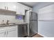 Modern kitchen with stainless steel appliances, white cabinetry, and tile backsplash at 640 N Nova Rd # 117, Ormond Beach, FL 32174
