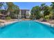 Inviting community pool with crystal-clear water, surrounded by lush landscaping and lounge chairs at 640 N Nova Rd # 117, Ormond Beach, FL 32174