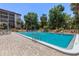 Outdoor community pool with crystal-clear water, surrounded by lush landscaping and lounge chairs at 640 N Nova Rd # 117, Ormond Beach, FL 32174