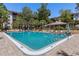 Community swimming pool with lounge seating, tables, and umbrellas, surrounded by landscaped foliage at 640 N Nova Rd # 117, Ormond Beach, FL 32174