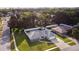 Aerial view of a single-story home in a tranquil neighborhood with lush trees and green lawns at 807 Scrub Oak St, South Daytona, FL 32119