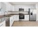 Bright kitchen featuring white cabinets, stainless steel appliances, and a granite countertop at 807 Scrub Oak St, South Daytona, FL 32119