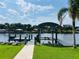 Covered boat dock with lift on waterfront property and lush, green landscaping at 992 Shockney Dr, Ormond Beach, FL 32174
