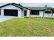 Charming single-story home with a well-manicured lawn, black trim, and a black garage door at 992 Shockney Dr, Ormond Beach, FL 32174
