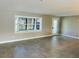 Bright living room featuring tile floors, neutral walls, a window with blinds, and a glass panel entry door at 992 Shockney Dr, Ormond Beach, FL 32174