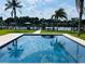 Crystal clear pool overlooking tranquil waterfront, enhanced by palm trees and blue sky at 992 Shockney Dr, Ormond Beach, FL 32174