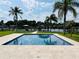 Sparkling pool with serene water views, framed by palm trees and lush greenery at 992 Shockney Dr, Ormond Beach, FL 32174