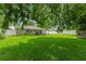 Lush backyard with healthy grass, mature trees, shed and white vinyl fence at 1719 Anniston Ave, Daytona Beach, FL 32117