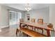 Bright dining area with long wooden table, bench, and sliding doors to the backyard at 2270 Wilmhurst Rd, Deland, FL 32720