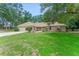 Well-maintained home with a lush front lawn and mature trees, with an attached two-car garage at 2270 Wilmhurst Rd, Deland, FL 32720