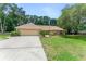 Well-maintained home with a lush front lawn and mature trees, with an attached two-car garage at 2270 Wilmhurst Rd, Deland, FL 32720