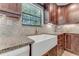 Farmhouse sink with granite counters and dark wood cabinets adds style and functionality at 2270 Wilmhurst Rd, Deland, FL 32720
