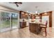Bright kitchen with wood cabinets, granite countertops, island with barstool seating, and sliding glass door at 2270 Wilmhurst Rd, Deland, FL 32720