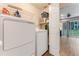 Functional laundry room with white washer and dryer, storage shelves, and open access to living area at 2270 Wilmhurst Rd, Deland, FL 32720