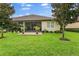 The backyard with green grass and screen-enclosed patio, great for relaxing outdoors at 3160 Bailey Ann Dr, Ormond Beach, FL 32174