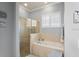 Bright bathroom featuring a bathtub and a shower with glass door, and tile surround at 3160 Bailey Ann Dr, Ormond Beach, FL 32174