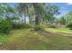 Large, grassy backyard featuring mature trees and privacy fencing, perfect for outdoor activities at 7686 Sw 81St St, Ocala, FL 34476