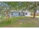 Charming single-story blue home with a well-maintained lawn and mature trees in a serene setting at 7686 Sw 81St St, Ocala, FL 34476
