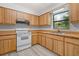 Well-lit kitchen featuring wooden cabinetry and a window with outside views at 7686 Sw 81St St, Ocala, FL 34476