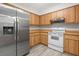 Well-lit kitchen featuring a stainless steel refrigerator and white appliances at 7686 Sw 81St St, Ocala, FL 34476