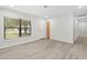 A neutrally-toned living room featuring new hardwood floors, smooth white walls, and natural light at 7686 Sw 81St St, Ocala, FL 34476