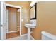 Bathroom featuring a pedestal sink, mirror, and doorway to another room at 902 Heron Point Cir, Deland, FL 32724