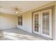 A cozy outdoor patio features a ceiling fan and double doors leading inside at 902 Heron Point Cir, Deland, FL 32724
