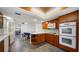 Kitchen features custom cabinets, stone tile flooring, and stainless steel appliances at 1 John Anderson Dr # 2180, Ormond Beach, FL 32176