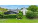Backyard featuring a screened-in pool area, mature trees, and manicured lawn at 101 Green Heron Ct, Daytona Beach, FL 32119