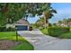 A long concrete driveway leads to a two-car garage, surrounded by lush landscaping, palm trees and green lawn at 101 Green Heron Ct, Daytona Beach, FL 32119