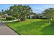 Well-manicured front lawn featuring a mature tree and a neatly paved driveway leading to the house at 101 Green Heron Ct, Daytona Beach, FL 32119