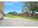 Large backyard features a shed, concrete patio, mature trees, and a brick fence at 106 Banyan Dr, Ormond Beach, FL 32176