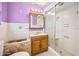 Cozy bathroom with white tiled walls, wood vanity, and glass shower door at 106 Banyan Dr, Ormond Beach, FL 32176