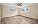 Well-lit bedroom features wood-look floors, two windows, and ceiling fan at 106 Banyan Dr, Ormond Beach, FL 32176