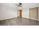 Spacious bedroom with wood-look flooring, ceiling fan, and closet with folding doors at 106 Banyan Dr, Ormond Beach, FL 32176