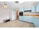 Eat-in kitchen with blue cabinetry, white refrigerator, and stylish ceiling fan at 106 Banyan Dr, Ormond Beach, FL 32176