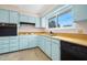 Bright eat-in kitchen features sky blue cabinetry and stainless steel appliances at 106 Banyan Dr, Ormond Beach, FL 32176