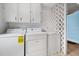 Laundry room with washer, dryer, storage cabinets and geometric divider at 106 Banyan Dr, Ormond Beach, FL 32176
