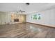 Spacious living room with a stone fireplace, ceiling fan, and large windows at 106 Banyan Dr, Ormond Beach, FL 32176
