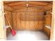 An interior view of a wooden shed complete with shelving and lighting for organized storage and functionality at 106 Banyan Dr, Ormond Beach, FL 32176