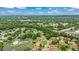 Aerial view of the community featuring a lake, tennis court, pool, and lush green surroundings at 12 Big Buck Trl, Ormond Beach, FL 32174