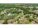 Aerial view of a neighborhood community with a scenic lake, tennis courts, and a pool at 12 Big Buck Trl, Ormond Beach, FL 32174