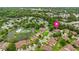 Aerial view of the property and surrounding community with the lake, tennis court, and pool at 12 Big Buck Trl, Ormond Beach, FL 32174