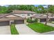 Well-maintained townhouse complex featuring lush landscaping, two-car garages, and stone accents at 12 Big Buck Trl, Ormond Beach, FL 32174