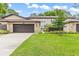 Charming townhome featuring a well-maintained lawn, a single-car garage, and stone accents at 12 Big Buck Trl, Ormond Beach, FL 32174