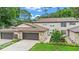 Charming two-story townhouse with a well-manicured lawn, stone accents, and a two-car garage at 12 Big Buck Trl, Ormond Beach, FL 32174