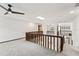 Second floor landing with wood railing, skylight and neutral carpet at 12 Big Buck Trl, Ormond Beach, FL 32174